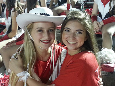 Senior Helena Posey (left) and freshman Charlotte Posey (right) hug at a game. Helena, a Lariette, was there to support the team, and Charlotte was there to support Helena.