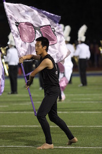 New Tech High @ Coppell senior and color guard member Dennis Shen performs in the halftime show during Friday night’s football game against McKinney Boyd at Ron Poe Stadium. Shen was involved in bans for 6 years before joining color guard for the 2016-2017 school year. Photo by Amanda Hair.