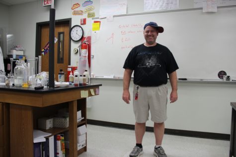 Coppell High School chemistry teacher Kevin Brimage wears his mixed and uncoordinated articles of clothing for Red Ribbon theme week last Monday in class. “It's my gangster, golfer, and rocker look,” Brimage explains, pointing to his rock band T-shirt, golfer shorts and sideways ball cap. Photo by Hannah Tucker.