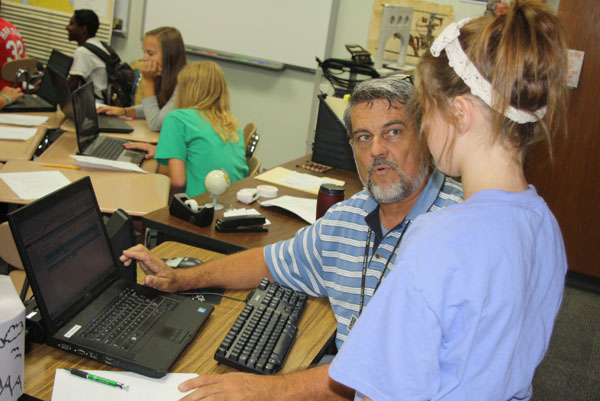 Kaylan Smith and her History teacher Mr. Harris discuss her grades and attendance records on the parent/teacher portal during her fourth period class. Photo by Trevor Stiff. 