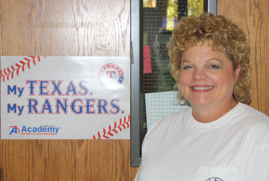 Mrs. Jackson poses in front of her classroom door next to her beloved Texas Rangers poster. Jackson recently won teacher of the month for October. Photo by Trevor Stiff. 