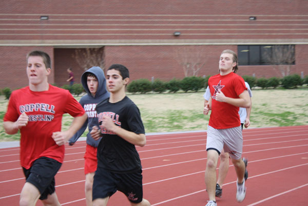 The Coppell varisty boys wrestling team warms up for a day of practice by running a few laps around the track. Photo by Ivy Hess. 