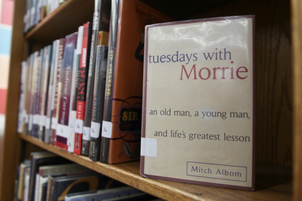 The book Tuesdays with Morrie sits on a bookshelf in the Coppell High School library. Photo by Trevor Stiff. 