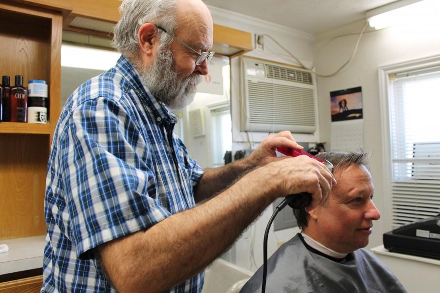 Photo by Mia Ford. Joe Shirley, owner of the Bethel Road Barber Shop, works his magic on his regular customer. Shirley runs a simple shop and strives to provide his customers with the best service possible.