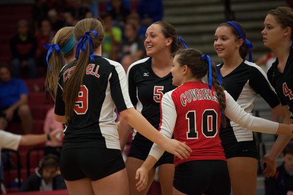 Teammates pat each other on the back after scoring a point against the Marcus volleyball team. Photo by Lauren Ussery.