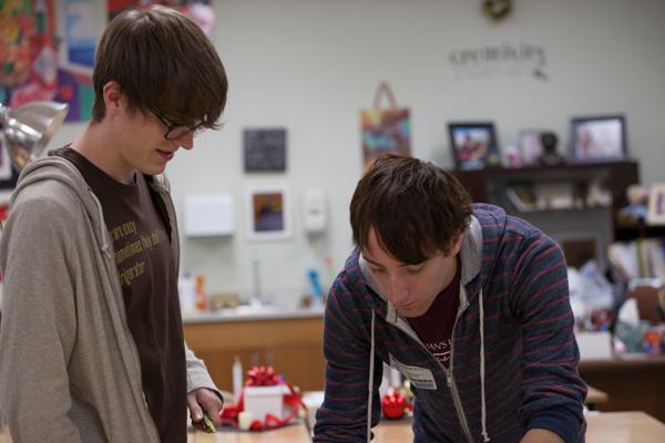 Scott (right) assists Huens (left) with a figure drawing for a college application. Photo by Lauren Ussery
