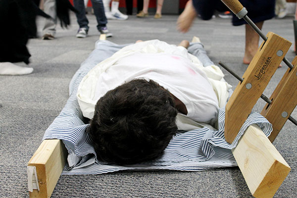 A student lies on wooden death bed to reenact the 1349 Bubonic Plague in English teacher Clara Caussey’s Academy English class on Friday. Photo by Rinu Daniel. 