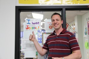 Austin elementary teacher John Pearson proudly shows off the sign his students made for him after he won Jeopardy. Photo by Sandy Iyer. 