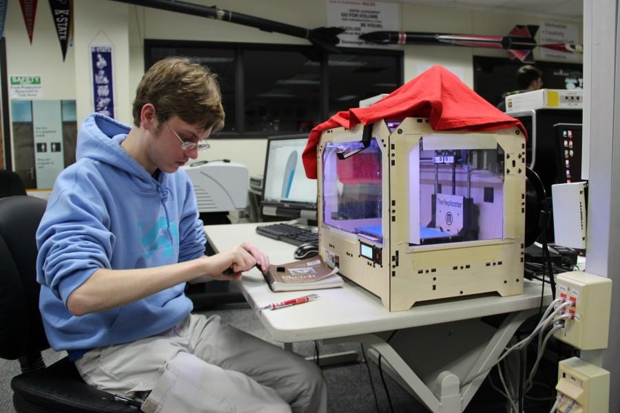 Senior Gunnar Schmidt works with a gear he printed for a project. Photo by Sandy Iyer.