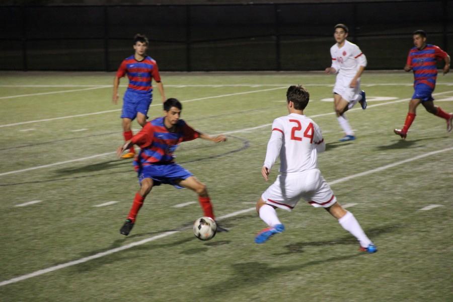 Coppell junior forward Colten Clark manuevers the ball around a Duncanville player in Tuesdays regional quarterfinal match at Birdville ISD Fine Arts/Athletic Complex. Coppell defeated Duncanville 2-0. Photo by Shannon Wilkinson.  