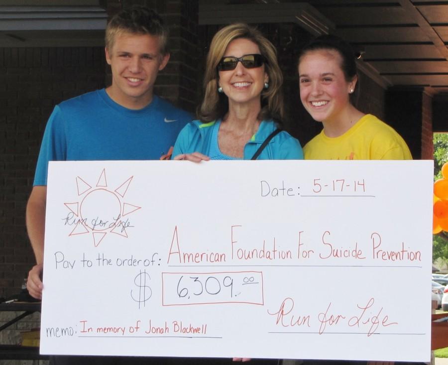 Junior Jessie Cranmer and Senior George Fairchild present a check of $6,309 to the American Foundation for Suicide Prevention on Saturday, May 17 after hosting the Run for Life 5K in honor of Jonah Blackwell. Photo by Kara Hallam