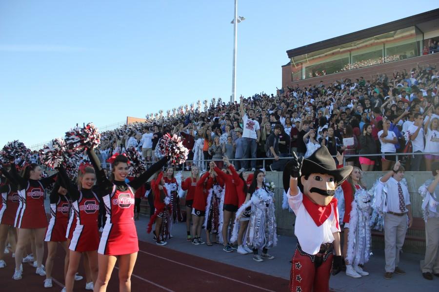 Coppell High School students raise their guns while singing their school song Oct. 17 at the homecoming pep rally in Buddy Echols Stadium. Photo by Nicole Messer.