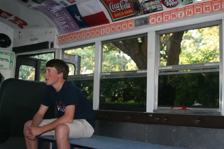 Junior Spencer Moore, as shown here, is the main man behind BUSTER 2.0 and along with his father and junior Jon Prez decked out the bus in crazy decorations. These decorations include Whataburger place numbers many Coppell High School students like to collect as well as various soft drink brand posters such as Coca-Cola and Dr. Pepper as shown here among other random, witty items drilled to the walls on the inside. Photo by Tuulia Koponen.