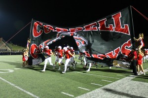 The Cowboys run through the banner made by the cheerleaders before the game against LD Bell. The game, on Sept. 26, was a 42-3 Cowboys win. Photo by Stephanie Alexander 