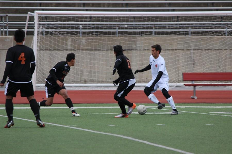 Senior Austin Michaelis dribbles between two WT White defenders Saturday Jan. 10. Coppell routed White 11-1.