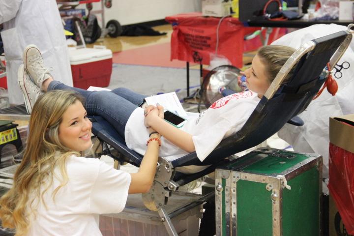 Senior Caroline Ward comforts senior friend Landry Walker as she donates blood during the Red Jacket’s second blood drive this year on Feb 13. in the small gym at Coppell High School. Photo by Sarah VanderPol. 
