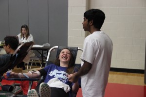 Senior red jacket Ashrith Reddy keeps senior Mackenzie Sork company as she donates blood during the Red Jacket’s second blood drive this year on Feb. 13 in the small gym at Coppell High School.  Photo by Sarah VanderPol.