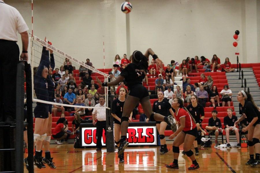 During the third set of the game, Coppell High School freshman Amarachi Osuji spikes the ball against the Richland Rebels, bringing the score to 9­-2, Coppell taking the lead. The Cowgirls won all three sets of the game, the first set with a score of 25-­13, the second with a score of 25-­15, and the third with a score of 25-­9, defeating the Rebels on Tuesday night in the CHS large gym.  Photo by Amanda Hair.