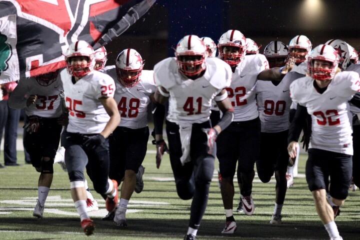 The Cowboys, led by senior defensive lineman Solomon Wise, run through the banner before the half. In Coppells 46