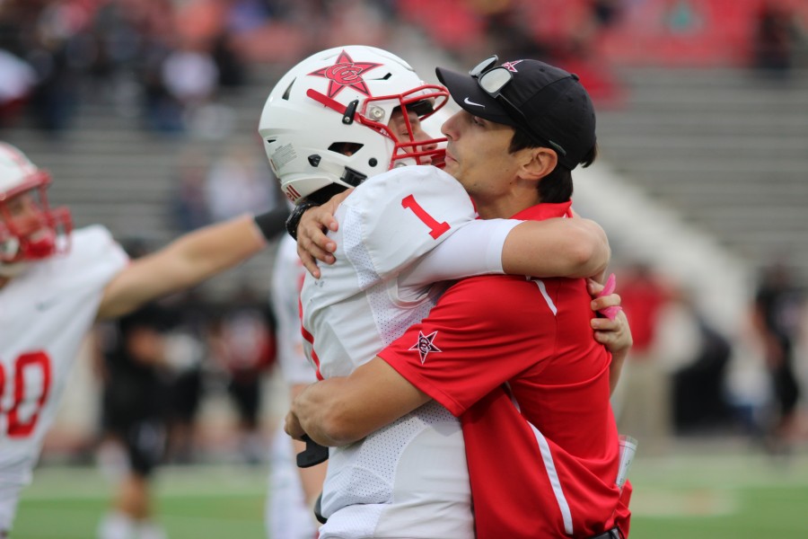 Coppell+High+School+sophomore+Wiley+Green+and+wide+receiver+coach+Nate+Blackwell+share+a+hug+after+Green+completed+the+final+play+in+Saturday%E2%80%99s+game+against+the+Colleyville+Heritage+Panthers+at+the+Mustang-Panther+Stadium.+Coppell+ended+the+game+with+a+victory+over+Colleyville+Heritage%2C+the+final+score+being+19-14.+Photo+by+Amanda+Hair.+