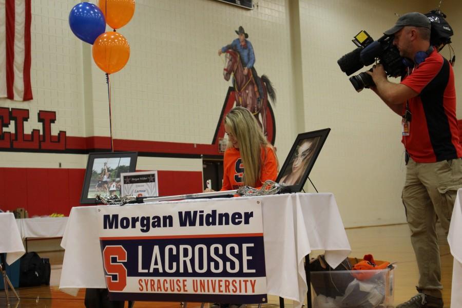 C2C Lacrosse defensive player Morgan Widner signs to Syracuse University to play lacrosse the morning of Nov. 11 in the CHS large gym. Nine CHS athletes signed their letters of intent on National Signing Day. Photo by Kelly Monaghan.