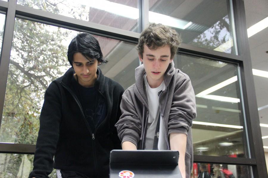 Coppell High School seniors Reyaan Shah and Preston Straus write the content of their next podcast show on Nov. 12 in the CHS library. Dramacast is a student created podcast featuring members of the CHS drama club. 