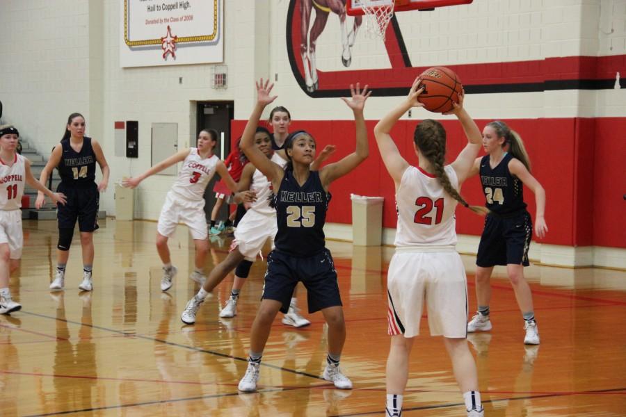 Coppell High School junior point guard Rachel Crutchfield waits for a teammate to get open while opposing Keller players block her on Nov 17 at Coppell High School. The Cowgirls fell to the Lady Indians 28-25. Photo by Aubrie Sisk. 