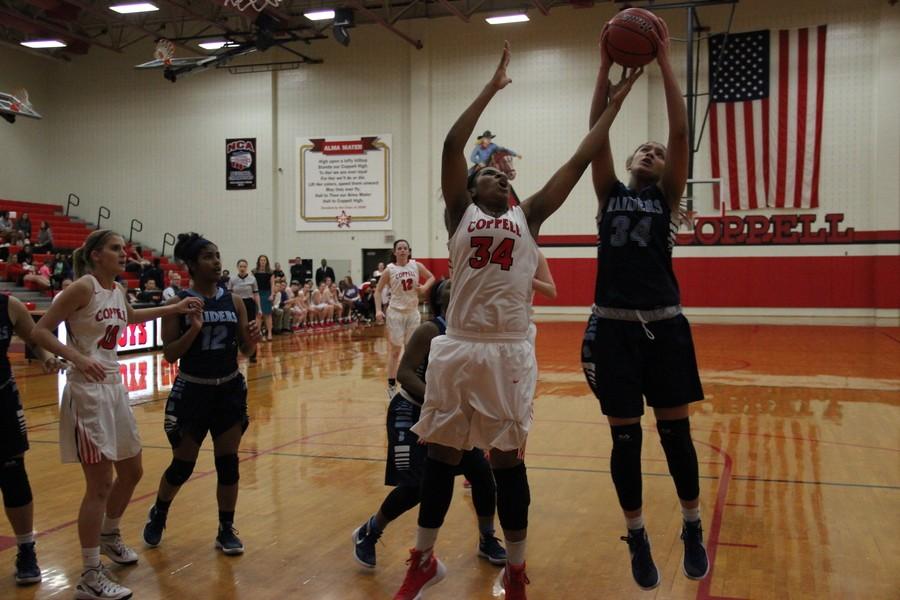 Coppell High School junior Chidera Nwaiwu attempts to intercept the ball from L. D. Bell High School junior Lexi Gordon during Tuesday night’s home game in the large gym. The cowgirls lost to L. D. Bell, 39-26. Photo by Ayoung Jo
