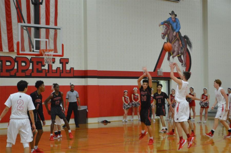 Coppell High School senior shooting guard Alex Vuchkov sinks a basket during the fourth quarter of Friday night’s home game played in the Coppell High School Large gym against the Trinity Trojans. The Cowboys beat the Trojans in a close 49-45 game. 