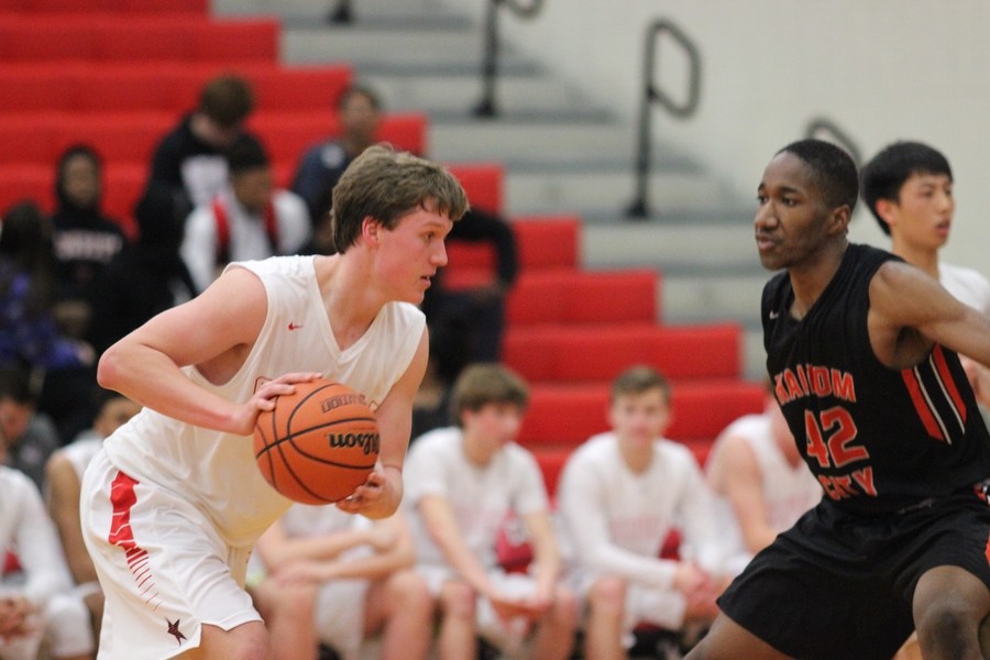 Coppell High School junior and forward Sam Marshall attempts to dribble around Haltom High School senior Emmanuel Egneti during the first quarter of Friday night’s game in the CHS large gym. Coppell took the win over Haltom with a final score of 50-45, moving to 6-0 in district play. 