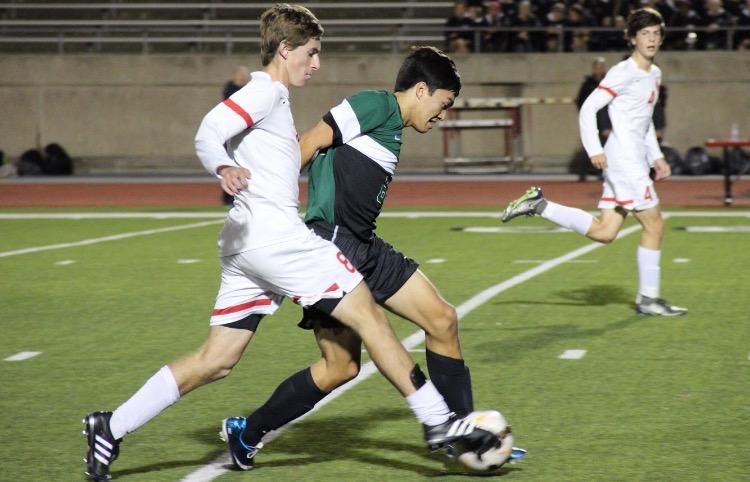 Coppell High School midfielder and senior Scott Simigian tries to run the ball post rivaling players in attempt to score during Friday night’s game at Buddy Echols Field. Coppell ended the game with a final score of 6-0, defeating Southlake Carroll. Photo by Amanda Hair.