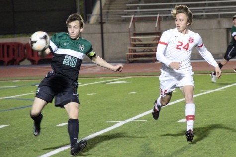 Coppell High School junior and midfielder Parker McClure looks to block an attempted pass from Southlake Carroll midfielders as the first half of Friday night’s game comes to a close. The Coppell Cowboys claimed a victory over the Southlake Carroll Dragons with a final score of 6-0. Photo by Amanda Hair.