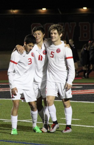 Coppell High School forwards Rodrigo Zuniga (left), Nick Taylor (middle), and Tanner Traw (right) all share a hug after Taylor scored the sixth and final goal of Friday night’s game against Southlake Carroll. After keeping the lead over Southlake Carroll for the entirety of the game, the Cowboys defeated the Dragons with a score of 6-0 at Buddy Echols Field. Photo by Amanda Hair.