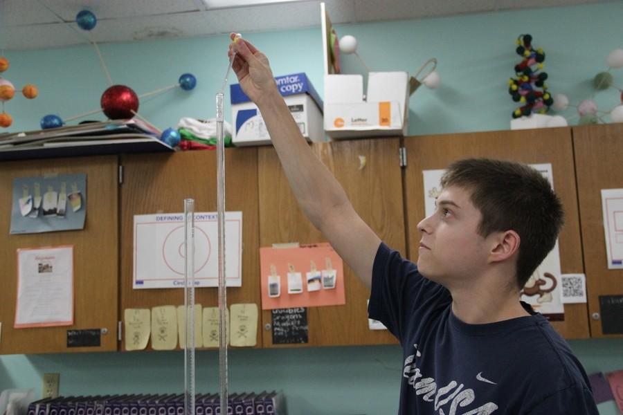 Coppell High School junior Phillip Smith uses a pipette to drop an acid solution into a buret on Monday in Amy Snyder’s AP chemistry classroom. The students in Snyder’s AP chemistry class are learning about titration curves of solutions of varying acidity. Photo by Ayoung Jo
