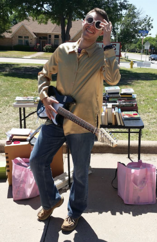 Former staff writer Mark Slette sports merchandise sold at the 2014 Sidekick Garage Sale. Photo by Alex Dalton. 