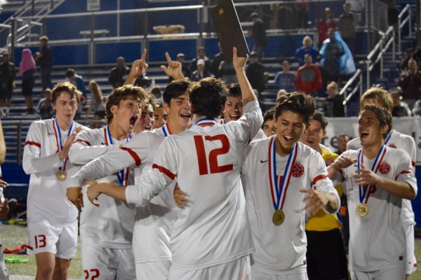 The Coppell Cowboys soccer teams celebrates senior Brandon Bohn’s Most Valuable Player award on Saturday night at Birkelbach Field in Georgetown. The Cowboys defeated Lake Travis, 6-1, in the state championship match, ending their undefeated season with a record of 24-0-2.