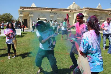 Coppell High School senior Venki Padala throws authentic Holi powder that was shipped from India at senior Pranathi Chitta at the DFW Hindu Temple on Sunday. The Holi powder was on sale for two dollars at the festival inside the Hindu Cultural Hall.