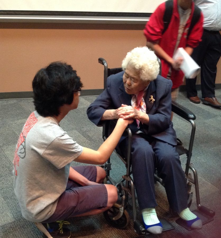 War survivor Lee Ok-Seon holds hands and talks personally with CHS junior Duyoung Cho. She thanked me for being here, and said that usually, they cant tell if there are any Korean people in the crowd, so she said it was nice of me to come up and talk to her, Cho said.