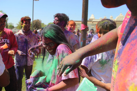 Coppell High School senior Chisom Ukoha throws Holi powder at senior Aditi Mukund during Holi at the DFW Hindu Temple on Sunday. “Every year I’ve gone to Holi at this temple, except for the last two years and the first time I came I was like five or six,” Mukund said. “I was really shocked at all the colors and a little scared. I saw everyone having a really great time and I just learned to enjoy it and have not missed a Holi since.”