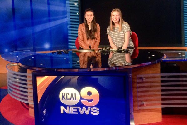 The Sidekick editor-in-chief Rachel Buigas-Lopez and staff photographer Amanda Hair pose as anchors at CBS Los Angeles after their tour of the facilities on Thursday. The Sidekick had the opportunity to watch parts of the life broadcast and ask the anchors, Leyna Nguyen and Sandra Mitchell, questions about their journalism career. 