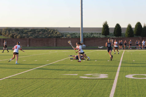 Junior Chaney Walker runs past a fallen ESD defender in pursuit of the goal in the state semifinal game. The Cowgirls lost the game 12-11. Photo by Joseph Krum.