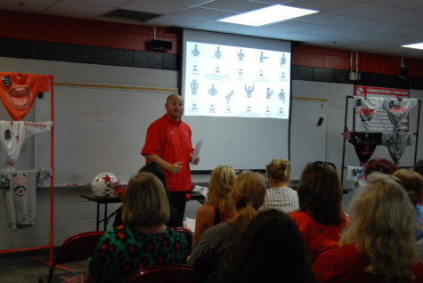 Tight ends coach Matt Smith goes over common penalties that referees call during games to the crowd. Smith also later went over signals that referees make throughout the game. Photo by Meara Isenberg.