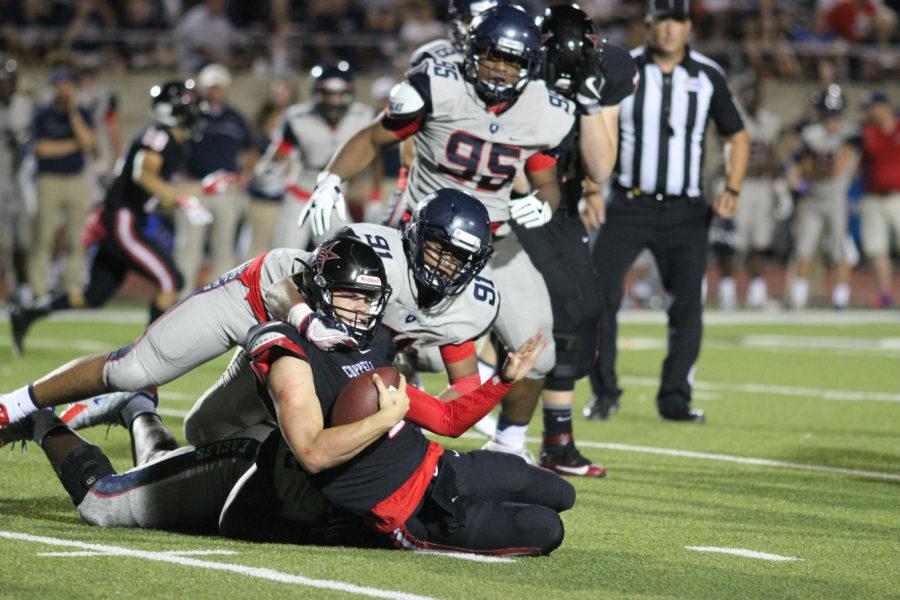 Coppell High School junior quarterback Brady Mcbride is tackled by Allen defensive linemen, Jayden Jernigan and Will Udo, during the fourth quarter of Friday night’s game to the Allen Eagles at Buddy Echols Field. Coppell had an early 10-7 lead in the first quarter, but couldn’t sustain it as the Eagles pulled off a 42-20 win over the Cowboys. 