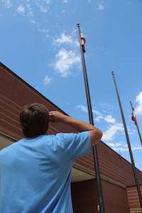 Coppell High School junior quarterback Brady McBride salutes the American flag. Standing up and respecting our flag is important, we should be proud of our country and show some respect towards it, McBride said. 