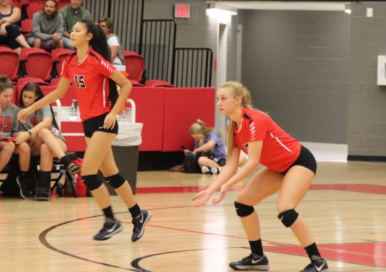 Coppell High School junior middle hitter Rylie Ross and sophomore outside hitter Pierce Woodall cheer as they win a point against Skyline during the first set of Friday night’s game. The Coppell Cowgirls defeated Skyline in the CHS arena, winning all three sets. 
