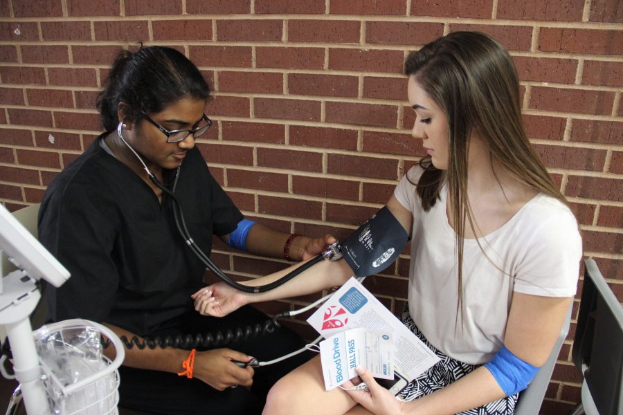 Coppell High School junior Navya Peddireddy checks senior Morgan Bryan’s pulse after Bryan gave blood in the Coppell High School small gym on Tuesday. Students in the medical endorsement and Red Jackets helped out at the blood drive.
Photo by Wren Lee