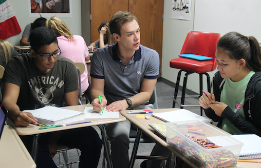 Spanish and English teacher Michael Egan helping his students with writing out phrases as they practice saying the sentences out loud.  Students have been working on a worksheet about these phrases since last Tuesday. 