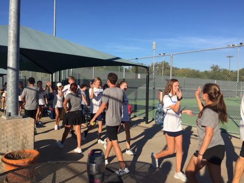 CHS tennis players exchange high-fives with Pierce High School players after winning 10-0 on Oct. 21. The CHS team will advance to regionals, hoping to continue their winning streak. 