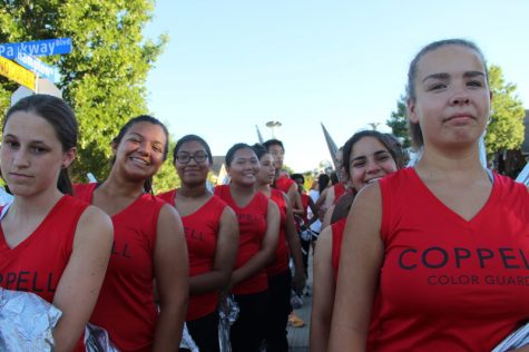 The Coppell High School color guard prepares for step off at the homecoming parade near Cottonwood Creek Elementary on Wednesday afternoon. The color guard led the parade right after the homecoming court while spinning silvery flags. Photo by Hannah Tucker.