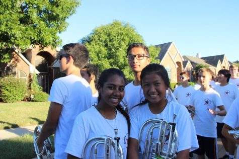 Coppell High School band members Rhea Shaw (sophomore), Joanne Chen (sophomore) and junior Aakash Talathi pose for a photo while getting set up in lines for the homecoming parade near Coppell High School on Wednesday afternoon. The annual parade starts about a mile down on Parkway Boulevard, which students walk to, and then leads back to the CHS parking lot. Photo by Hannah Tucker.